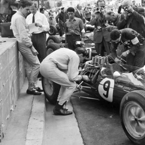 Aux essais à Monaco, Jim aide à changer les bougies de la Lotus 25 sous l'oeil amusé de Trevor Taylor Aux essais à Monaco, Jim aide à changer les bougies de la Lotus 25 sous l'oeil amusé de Trevor Taylor